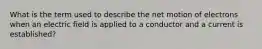 What is the term used to describe the net motion of electrons when an electric field is applied to a conductor and a current is established?