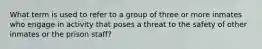 What term is used to refer to a group of three or more inmates who engage in activity that poses a threat to the safety of other inmates or the prison staff?