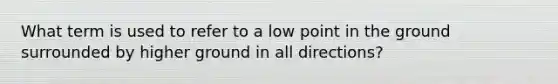 What term is used to refer to a low point in the ground surrounded by higher ground in all directions?