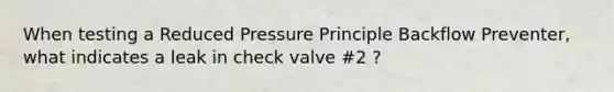 When testing a Reduced Pressure Principle Backflow Preventer, what indicates a leak in check valve #2 ?