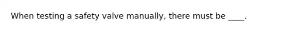 When testing a safety valve manually, there must be ____.