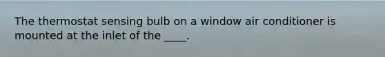 The thermostat sensing bulb on a window air conditioner is mounted at the inlet of the ____.