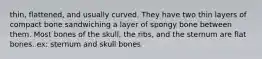 thin, flattened, and usually curved. They have two thin layers of compact bone sandwiching a layer of spongy bone between them. Most bones of the skull, the ribs, and the sternum are flat bones. ex: sternum and skull bones