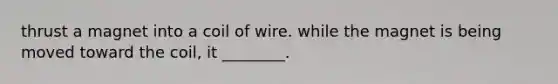 thrust a magnet into a coil of wire. while the magnet is being moved toward the coil, it ________.