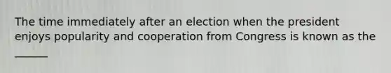 The time immediately after an election when the president enjoys popularity and cooperation from Congress is known as the ______