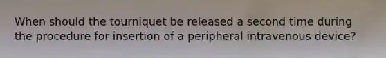 When should the tourniquet be released a second time during the procedure for insertion of a peripheral intravenous device?
