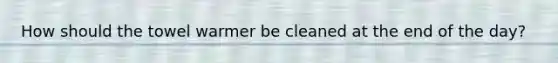 How should the towel warmer be cleaned at the end of the day?