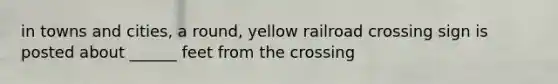 in towns and cities, a round, yellow railroad crossing sign is posted about ______ feet from the crossing