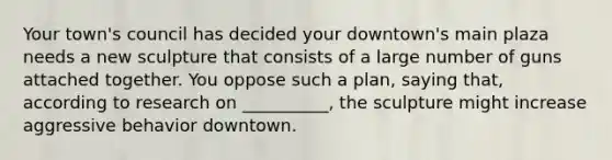 Your town's council has decided your downtown's main plaza needs a new sculpture that consists of a large number of guns attached together. You oppose such a plan, saying that, according to research on __________, the sculpture might increase aggressive behavior downtown.