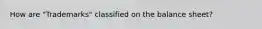 How are "Trademarks" classified on the balance sheet?
