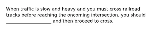 When traffic is slow and heavy and you must cross railroad tracks before reaching the oncoming intersection, you should ____________________ and then proceed to cross.