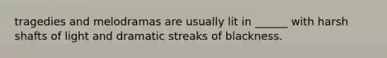 tragedies and melodramas are usually lit in ______ with harsh shafts of light and dramatic streaks of blackness.