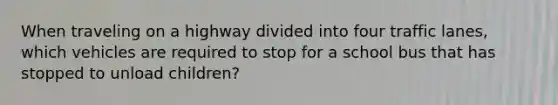 When traveling on a highway divided into four traffic lanes, which vehicles are required to stop for a school bus that has stopped to unload children?