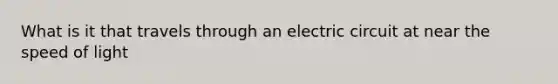 What is it that travels through an electric circuit at near the speed of light