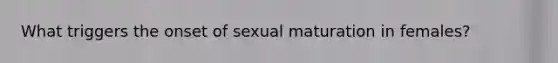 What triggers the onset of sexual maturation in females?