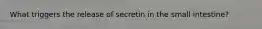 What triggers the release of secretin in the small intestine?