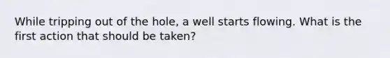 While tripping out of the hole, a well starts flowing. What is the first action that should be taken?