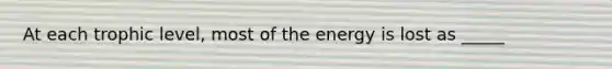 At each trophic level, most of the energy is lost as _____