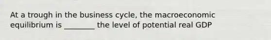 At a trough in the business cycle, the macroeconomic equilibrium is ________ the level of potential real GDP