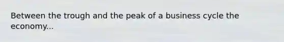 Between the trough and the peak of a business cycle the economy...