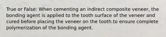 True or False: When cementing an indirect composite veneer, the bonding agent is applied to the tooth surface of the veneer and cured before placing the veneer on the tooth to ensure complete polymerization of the bonding agent.