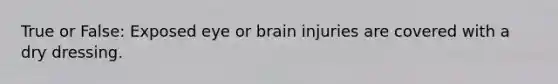 True or False: Exposed eye or brain injuries are covered with a dry dressing.