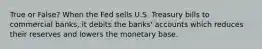 True or False? When the Fed sells U.S. Treasury bills to commercial banks, it debits the banks' accounts which reduces their reserves and lowers the monetary base.