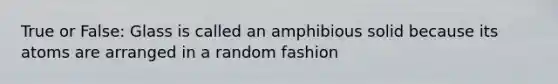 True or False: Glass is called an amphibious solid because its atoms are arranged in a random fashion