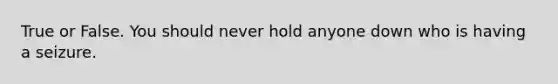 True or False. You should never hold anyone down who is having a seizure.