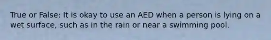 True or False: It is okay to use an AED when a person is lying on a wet surface, such as in the rain or near a swimming pool.