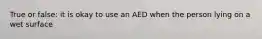 True or false: it is okay to use an AED when the person lying on a wet surface