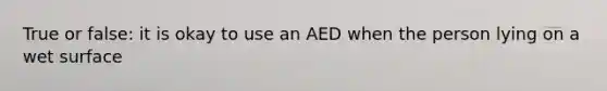 True or false: it is okay to use an AED when the person lying on a wet surface