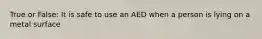 True or False: It is safe to use an AED when a person is lying on a metal surface