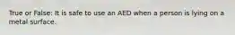 True or False: It is safe to use an AED when a person is lying on a metal surface.