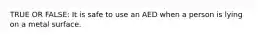 TRUE OR FALSE: It is safe to use an AED when a person is lying on a metal surface.