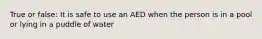 True or false: It is safe to use an AED when the person is in a pool or lying in a puddle of water