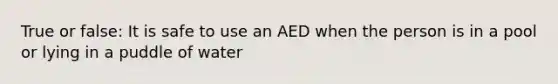 True or false: It is safe to use an AED when the person is in a pool or lying in a puddle of water