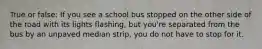 True or false: If you see a school bus stopped on the other side of the road with its lights flashing, but you're separated from the bus by an unpaved median strip, you do not have to stop for it.