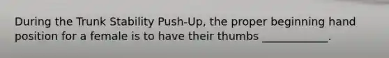 During the Trunk Stability Push-Up, the proper beginning hand position for a female is to have their thumbs ____________.
