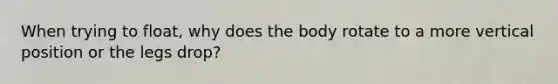 When trying to float, why does the body rotate to a more vertical position or the legs drop?