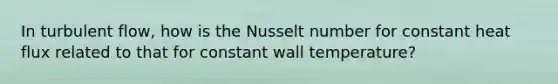 In turbulent flow, how is the Nusselt number for constant heat flux related to that for constant wall temperature?