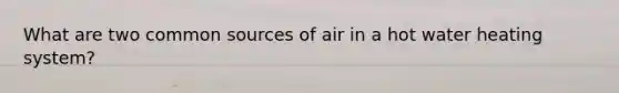 What are two common sources of air in a hot water heating system?