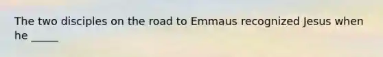 The two disciples on the road to Emmaus recognized Jesus when he _____