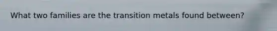 What two families are the transition metals found between?