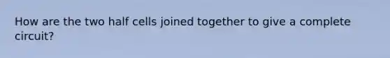 How are the two half cells joined together to give a complete circuit?