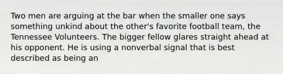 Two men are arguing at the bar when the smaller one says something unkind about the other's favorite football team, the Tennessee Volunteers. The bigger fellow glares straight ahead at his opponent. He is using a nonverbal signal that is best described as being an