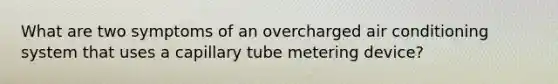 What are two symptoms of an overcharged air conditioning system that uses a capillary tube metering device?