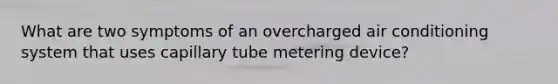 What are two symptoms of an overcharged air conditioning system that uses capillary tube metering device?