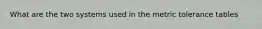 What are the two systems used in the metric tolerance tables