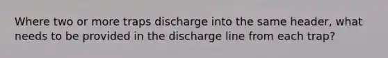 Where two or more traps discharge into the same header, what needs to be provided in the discharge line from each trap?